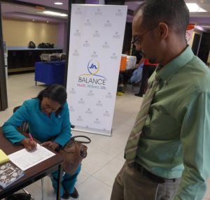 Janice Green (left), occupational health and safety officer in the JN Group Human Resource Development, gets assistance from Igol Allen, blood drive coordinator, National Blood Transfusion Service.