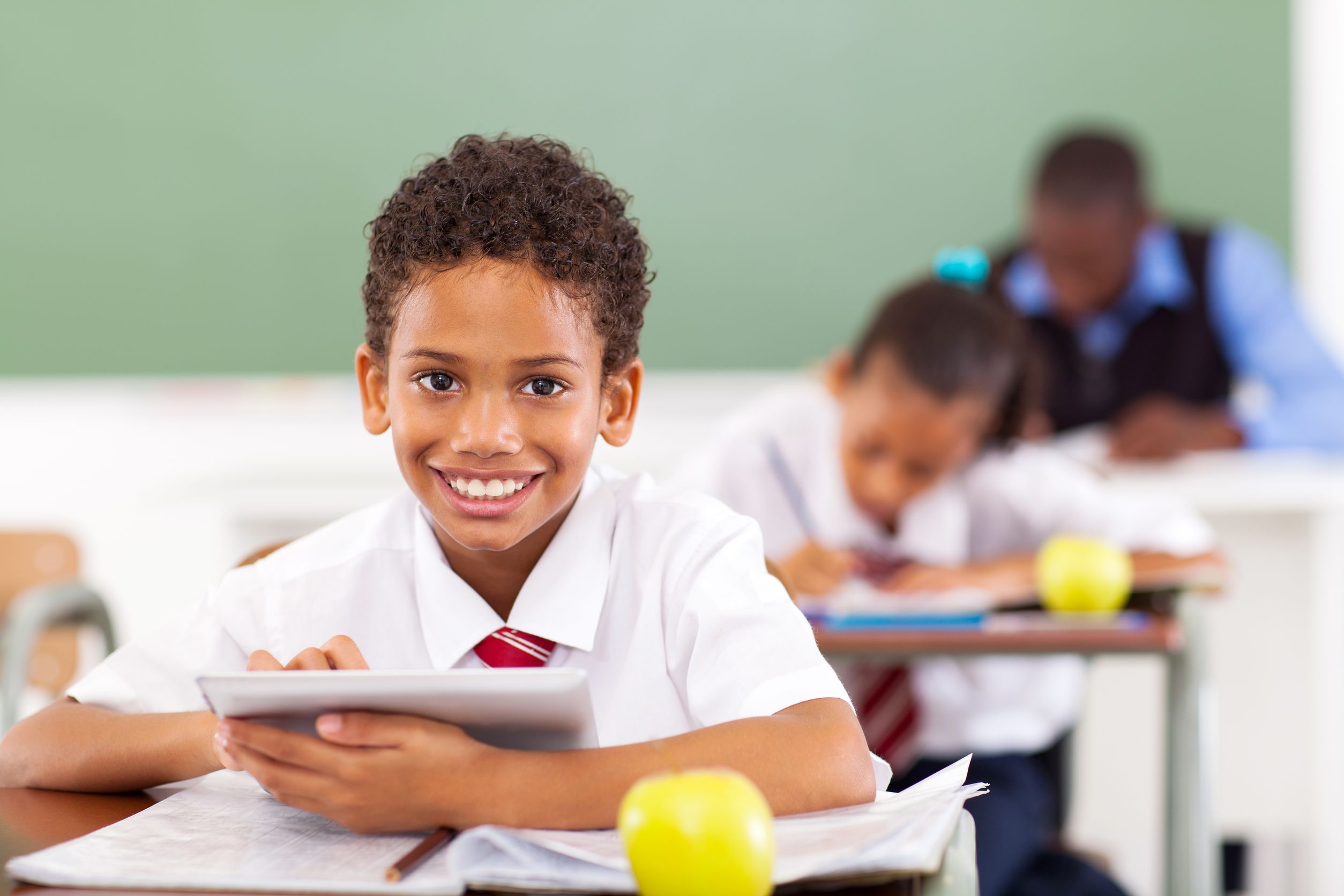 primary school boy using tablet in classroom