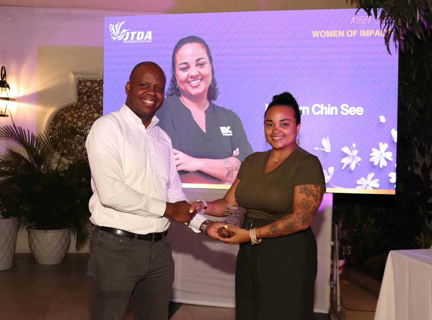 Almando Cox, president, Jamaica Digital and Technology Alliance (JTDA), presents the Woman of Impact Award in STEAM in Jamaica to Kathryn Chin See, Product Manager, BizPay, at MC Systems, for her contribution and work in the Jamaican tech space over the year.